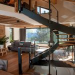 Moderný drevený interiér chaty s točitým schodiskom a výhľadom