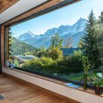 Alpská chata s veľkorozmerným oknom s výhľadom na Alpy