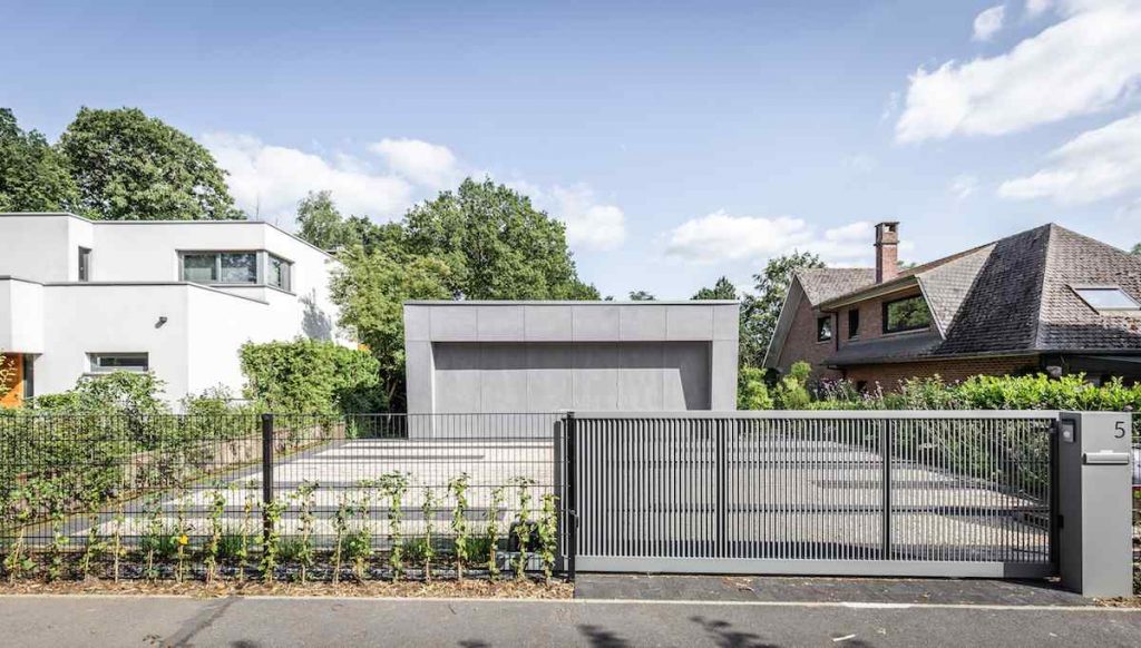 Nízka sivá stavba so šedým kovovým plotom
