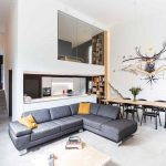 Moderná obývačka s vysokým stropom a preskleným boxom so spálňou