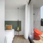 Moderná spálňa s presklenou terasou a dizajnovým kreslom