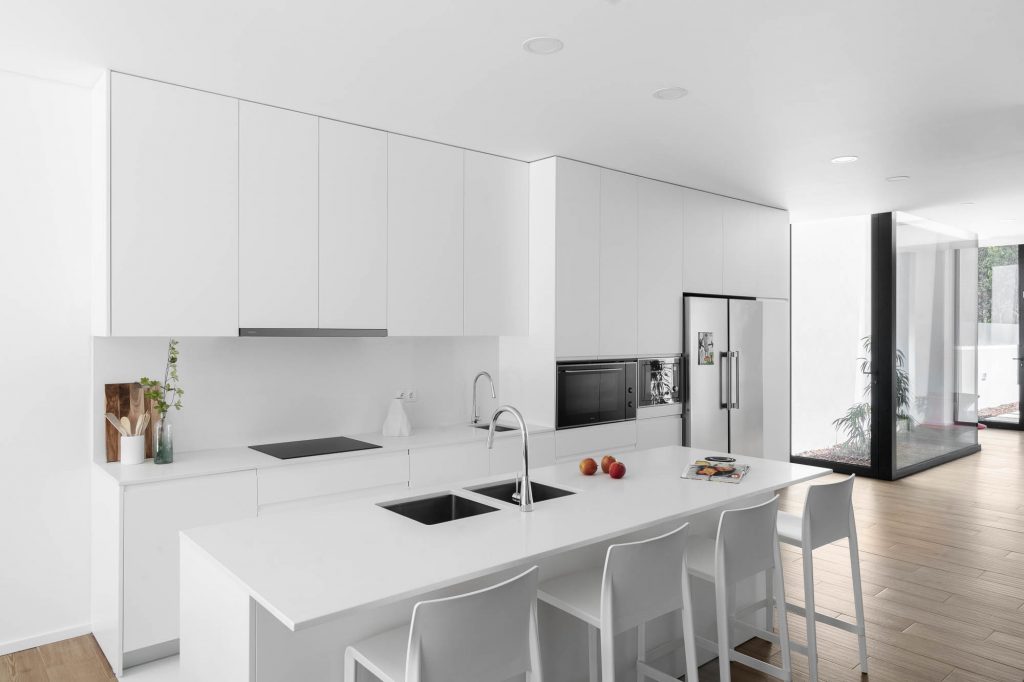 Moderná biela kuchyňa so svetlou podlahou vo vile