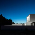 Moderná čiernobiela geometrická vila v noci