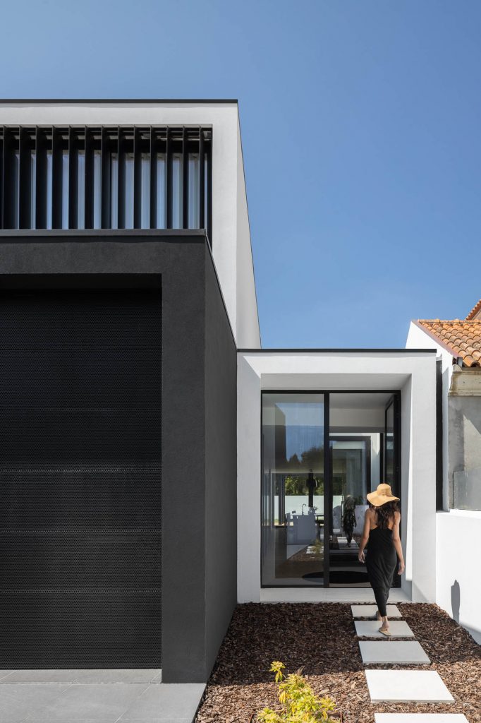 Moderná čiernobiela geometrická vila so ženou vchádzajúcou