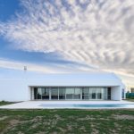 Biely moderný prízemný dom s presklením a bazénom