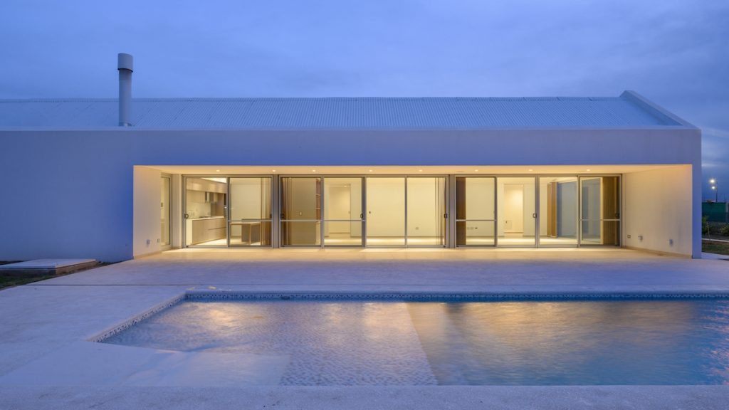 Biely moderný prízemný dom s presklením a bazénom