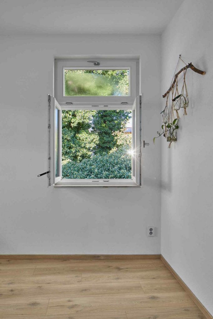 Štvorcové okno v izbe s drevenou podlahou