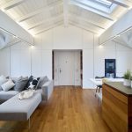 Strešný byt s bielym dreveným krovom hnedým nábytkom