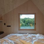 Podkrovná spálňa so šikmou strechou s oknom na priehradu