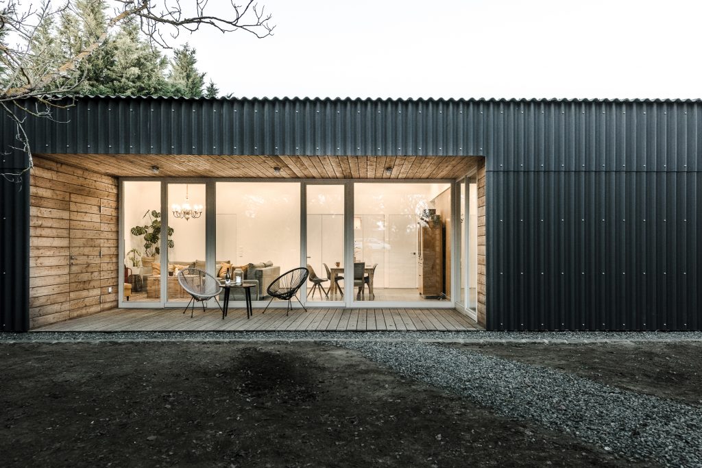 Jednopodlažný rodinný dom potiahnutý čiernou vlnitou bridlicou s presklenou terasou