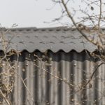 Detail fasády domu potiahnutej čiernou vlnitou bridlicou
