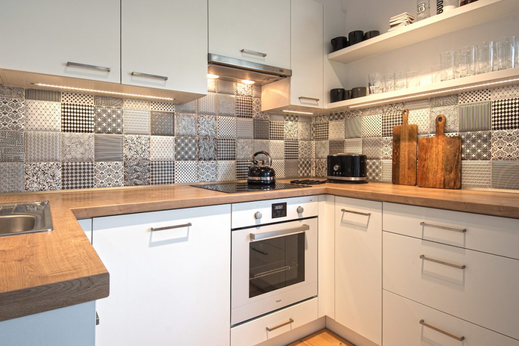 Biela kuchyňa s čiernobielou vzorovanou zástenou