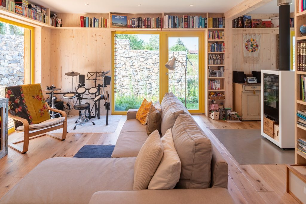 Obývačka so sivou pohovkou, francúzkymi oknami a knižnicami