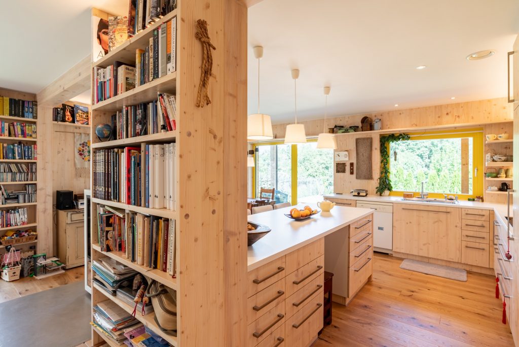 Veľká svetlá drevená kuchyňa s drevenou podlahou a knižnicou