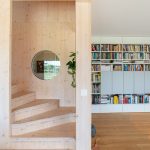 Obývačka s knižnicou a schodiskom v drevostavbe