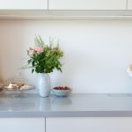 Biela kuchyňa s kyticou kvetov