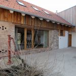Stará hospodárska budova prerobená s kamennou stenou na bývanie