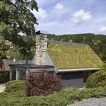 Domček s mohutným kamenným komínom, zelenou strechou a zimnou záhradou