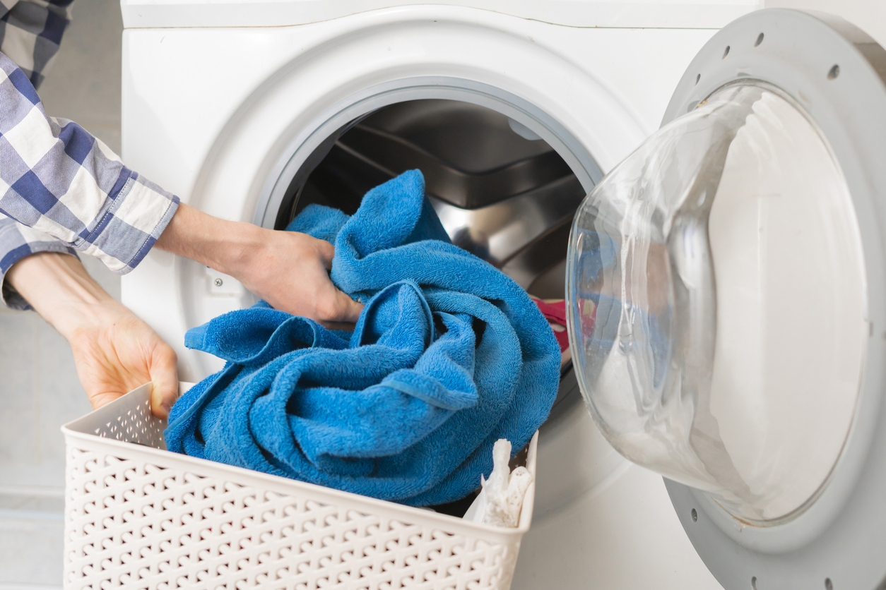 Osoba dáva do práčky špinavé prádlo