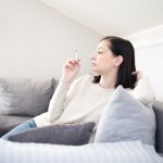 Žena fajčí na gauči v byte