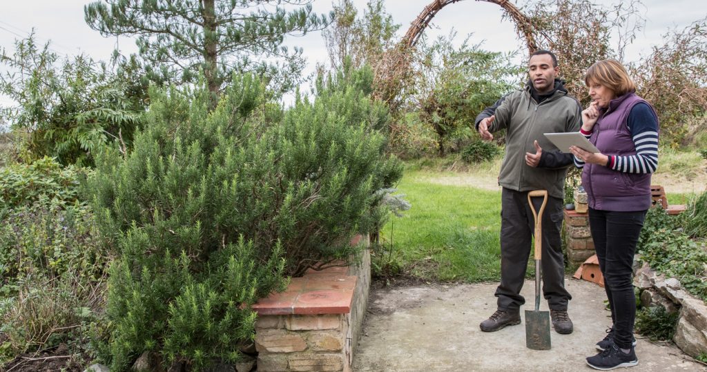 Záhradný architekt vysvetľuje zákazníčke v záhrade