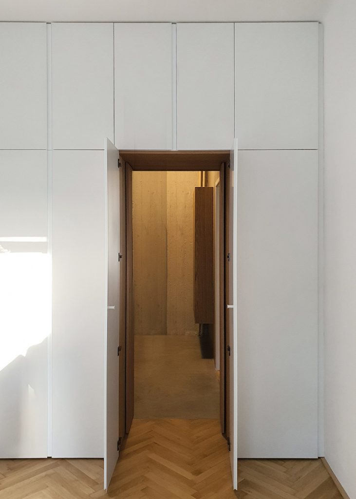 Biela vstavaná skriňa v spálni s vchodom do kúpeľne