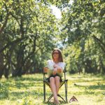 Žena sediaca na stoličke v sade