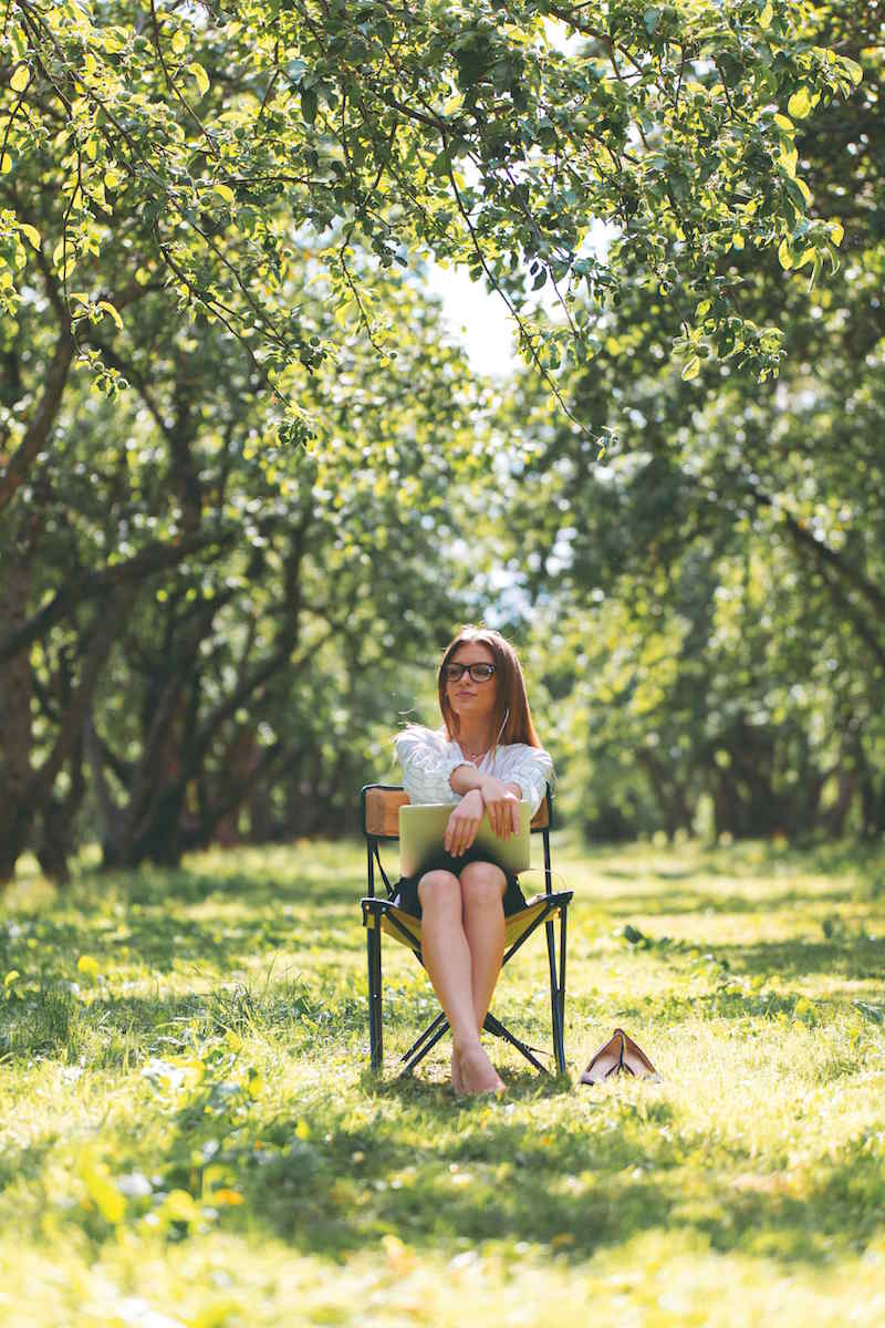 Žena sediaca na stoličke v sade