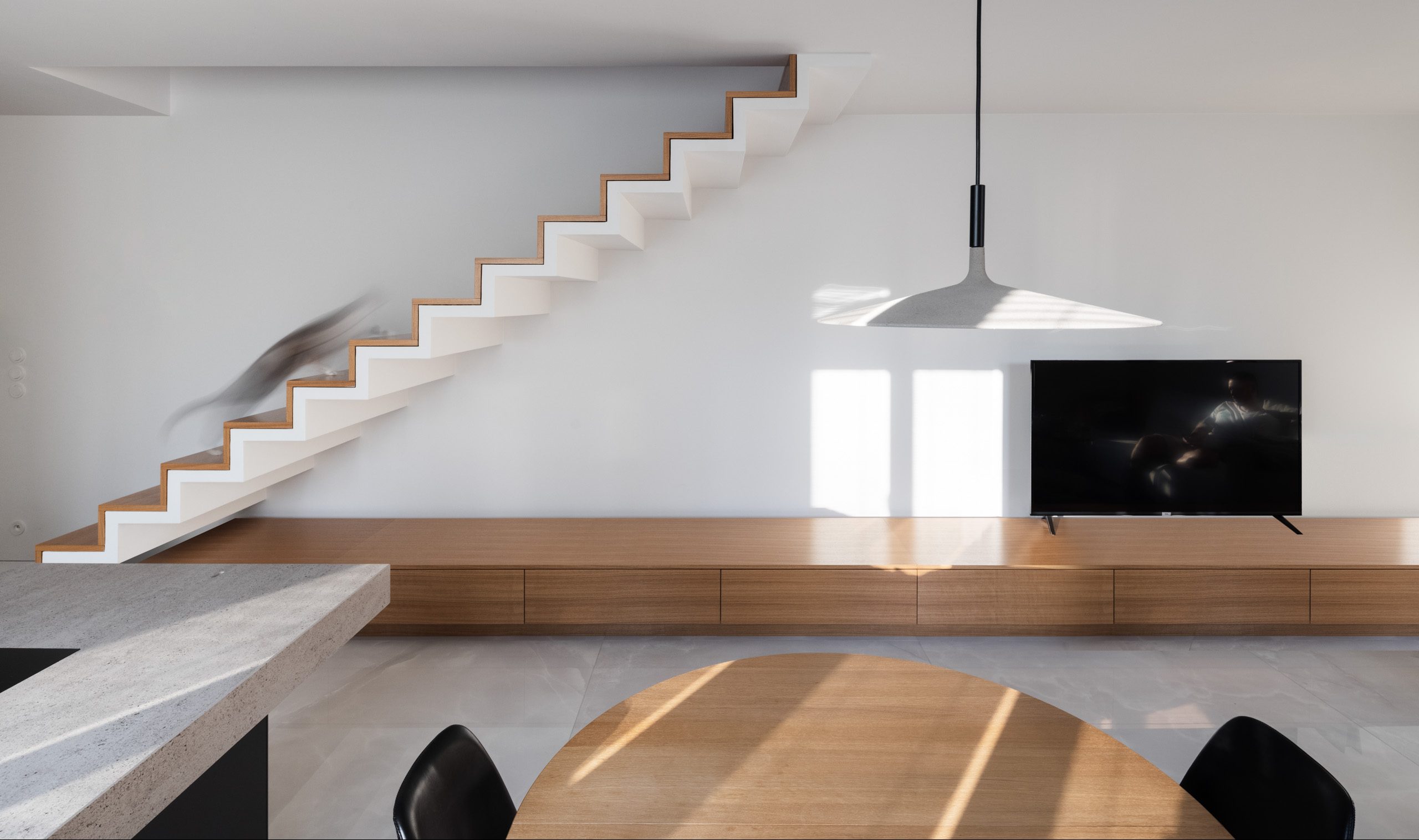 Pravouhlé tvary nábytku, schodov, hrany dverí architekt zmäkčil použitím okrúhlych prvkov interiéru.