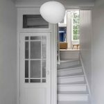 Biela chodba so schodiskom v úzkom holandskom dome