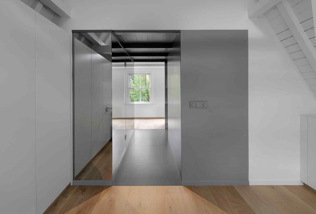 Spálňa so sivou stenou a zrkadlovou chodbou