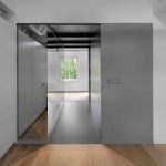 Spálňa so sivou stenou a zrkadlovou chodbou