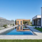 Moderný jednopodlažný rodinný dom s veľkým presklením s výhľadom na bazén