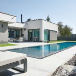 Moderný jednopodlažný rodinný dom s veľkým presklením s výhľadom na bazén