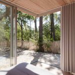 Útulná spálňa v drevenej vile s presklením do záhrady