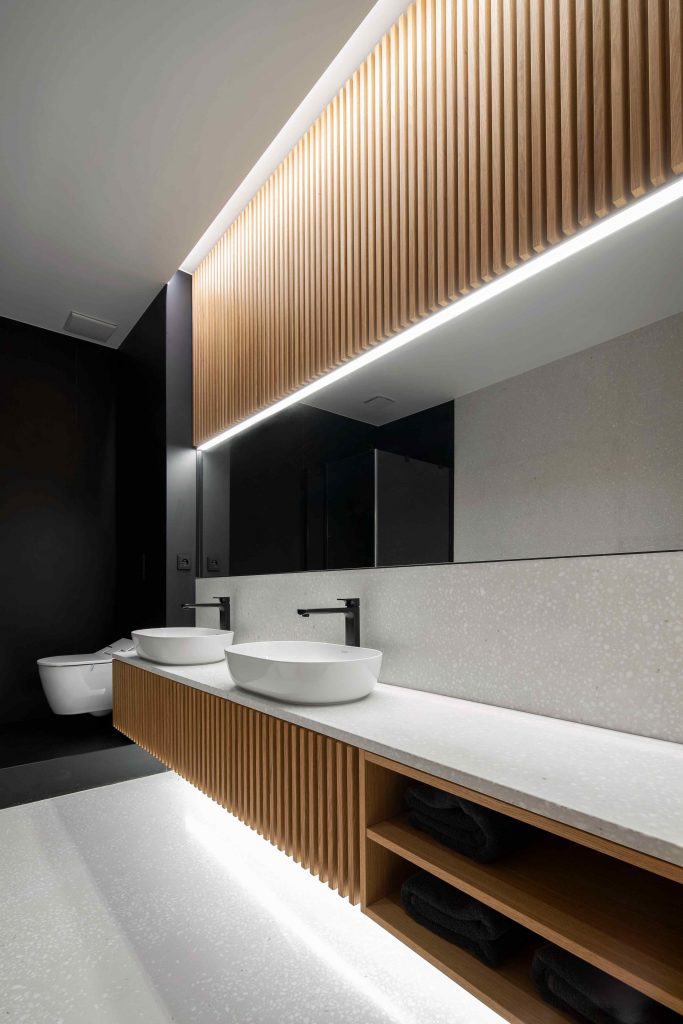 Moderná čiernobiela kúpeľňa s drevenými lamelmi