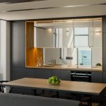 Podsvietená moderná hnedá kuchyňa so zrkadlovou zástenou