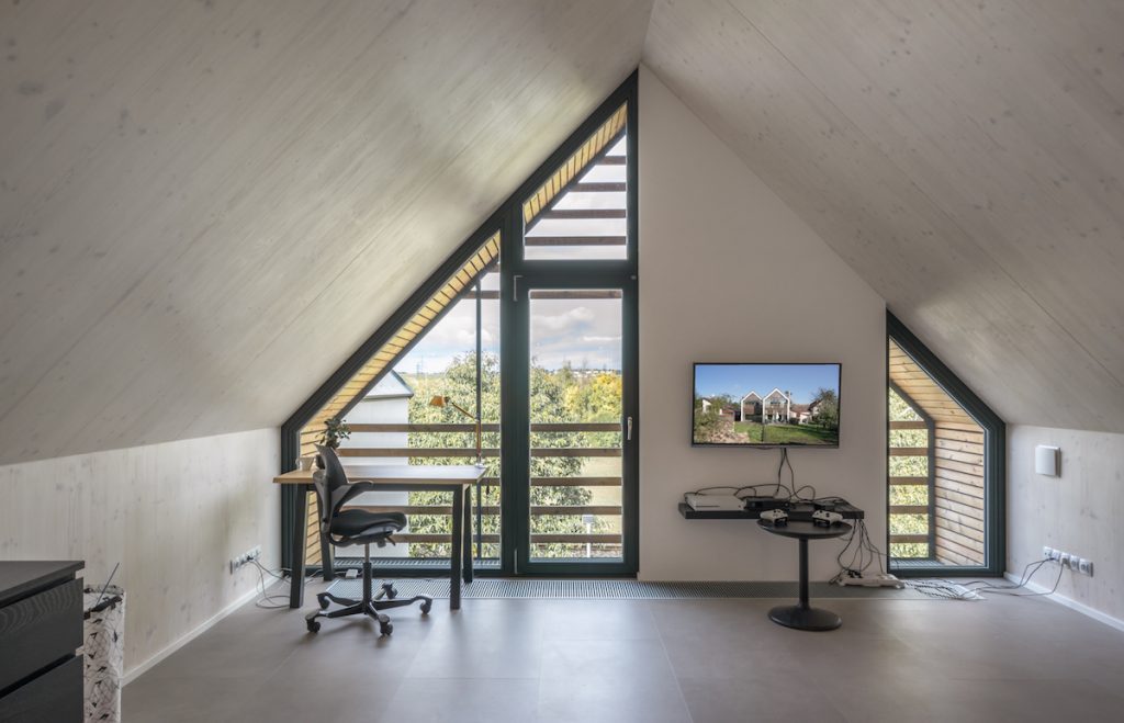Podkrovná kancelária s drevenými lamelmi na oknách