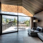 Moderná tmavohnedá obývačka v chate s výhľadom na Alpy