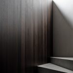 Sivé schodisko s tmavohnedou stenou