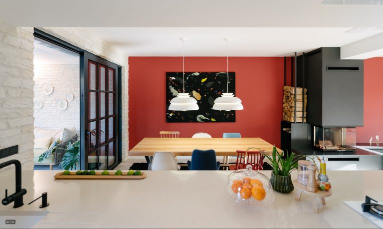 Obývačka s červenou stenou a svetlou sedačkou