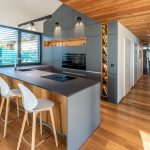 Moderná sivo drevená kuchyňa s jedálňou v dome
