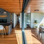 Moderná sivo drevená kuchyňa s jedálňou v dome s terasou