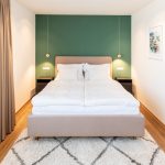 Spálňa s ružovou posteľou a zelenou stenou