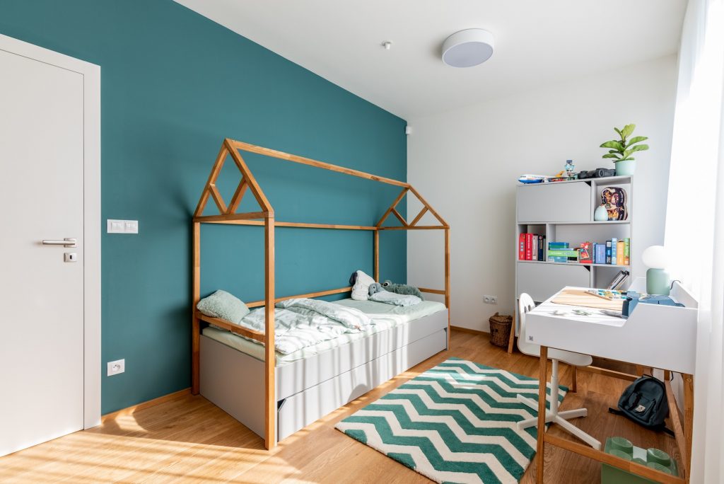 Detská izba s domčekovou posteľou a zelenou stenou