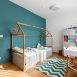 Detská izba s domčekovou posteľou a zelenou stenou