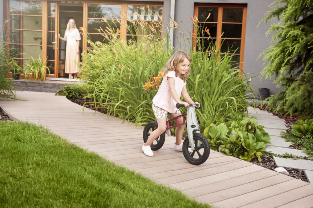 Dievčatko sa bicykluje po chodníku z komppozitu