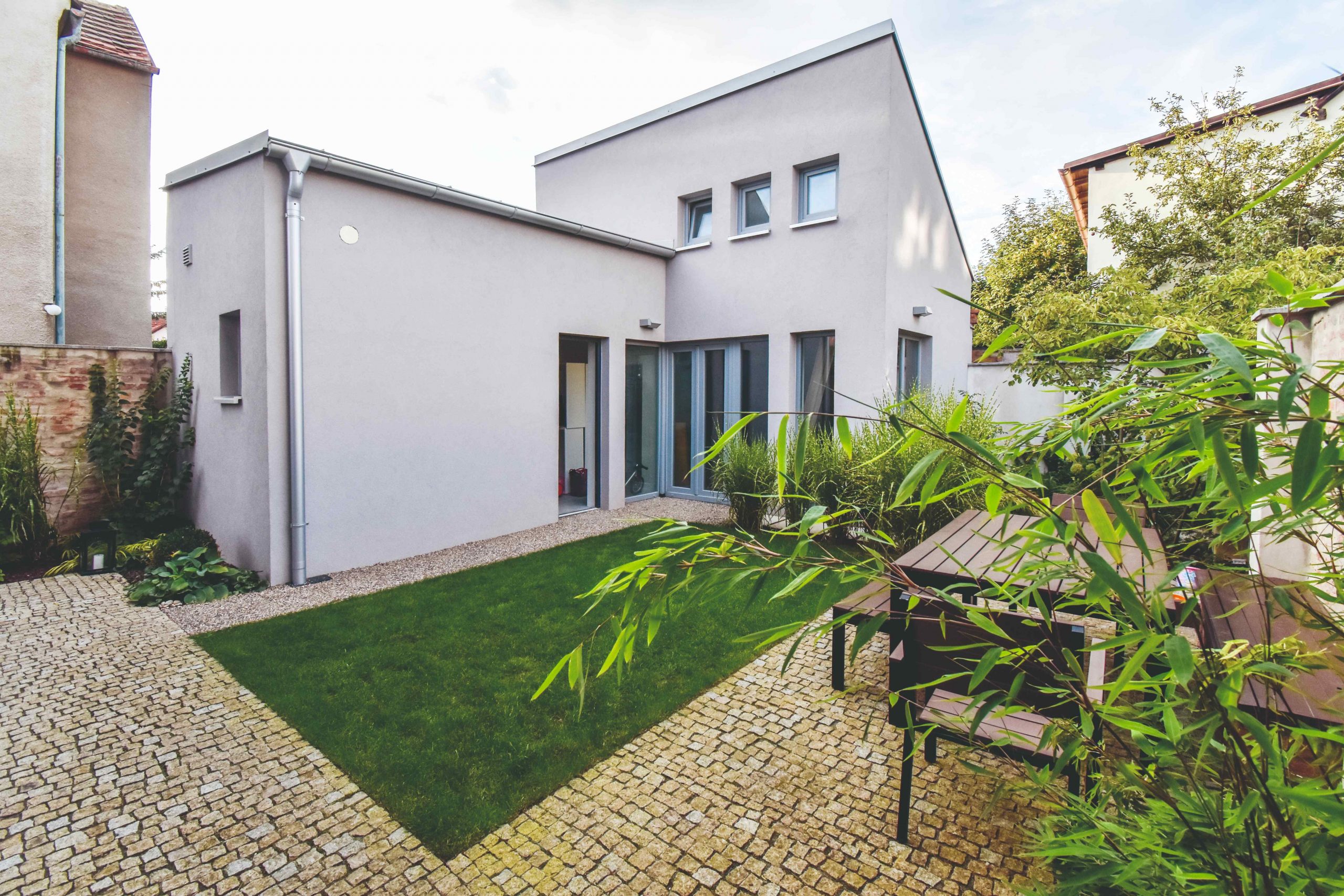 Jednoduchému nádvoriu dominuje trávnik umiestnený v jeho strede. Tvar a vzhľad chodníčkov architekti prispôsobili obom existujúcim domom. Celé átrium vrátane zelene je koncipované minimalisticky, s prihliadnutím na jednoduchú údržbu, ktorá bola jednou zo základných požiadaviek majiteľov.