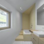 Biela moderná asymetrická kúpeľňa so žltou stenou
