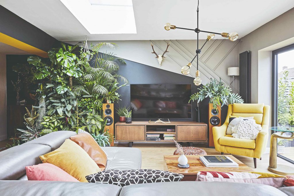 Obývačka s čiernou stenou a veľkou kvetinovou džungľou
